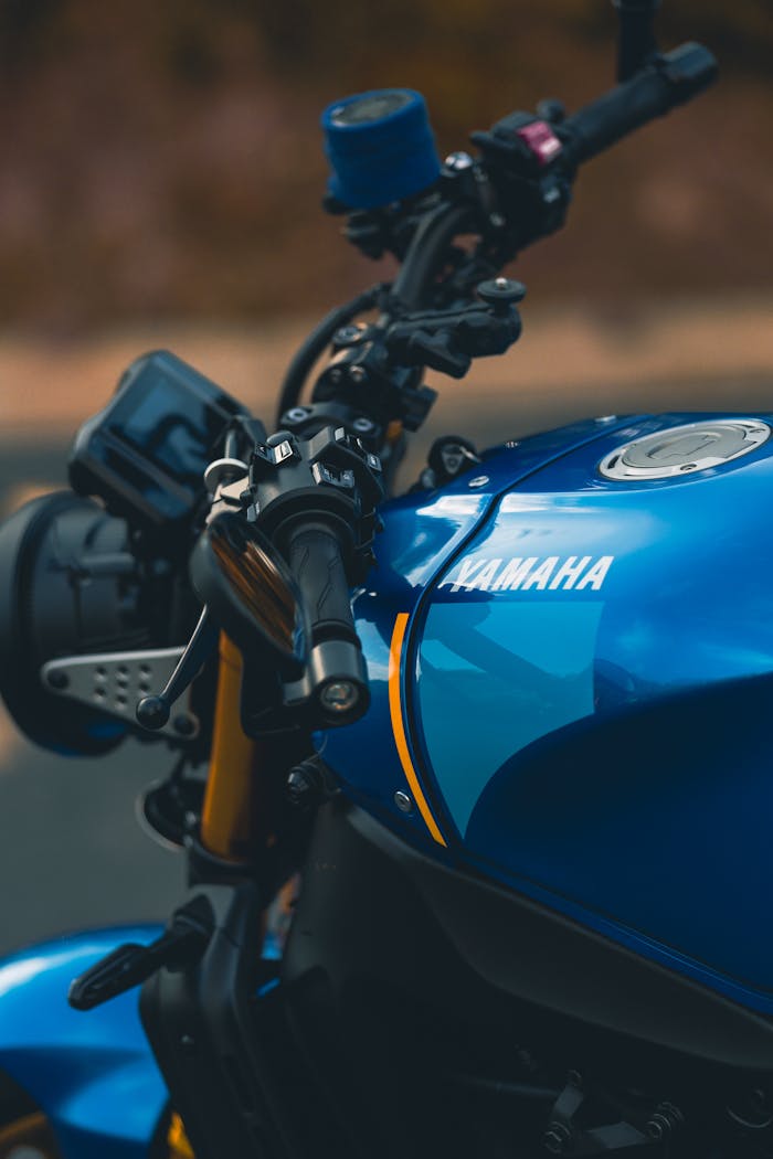 Detailed view of a blue Yamaha motorcycle handlebar and tank in natural light.